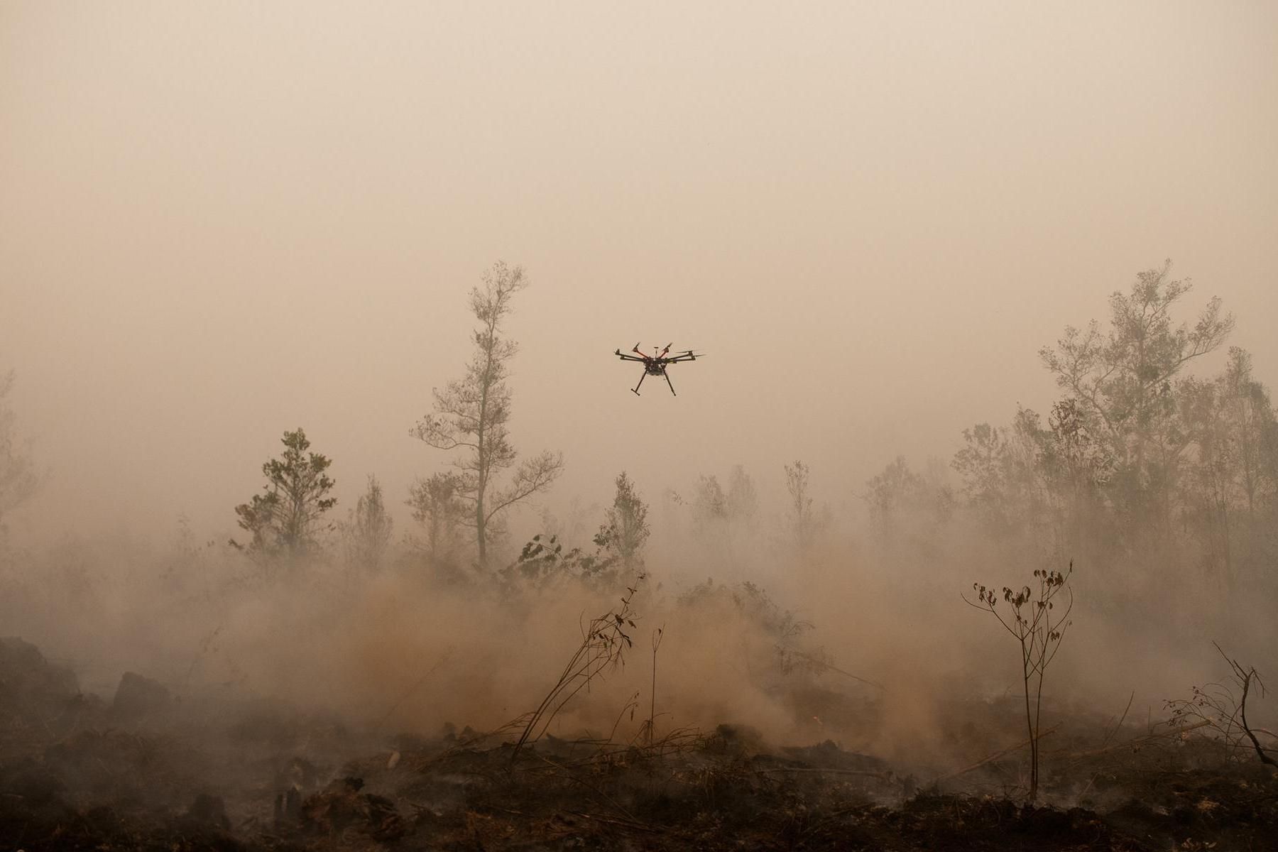 Беспилотный летательный аппарат пролетает над горящим торфяником Центрального Калимантана