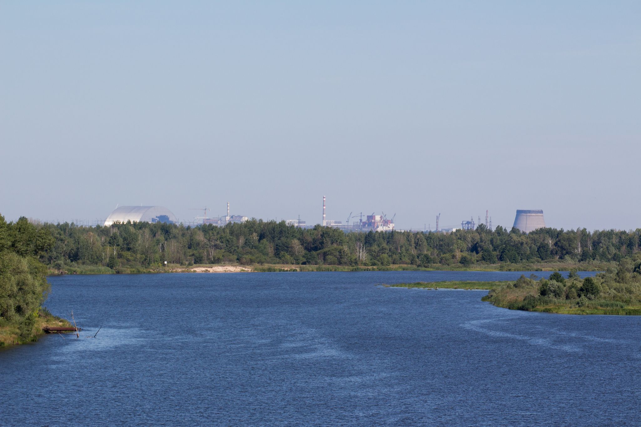 На фоне ракі Прыпяць бачная Чарнобыльская АЭС