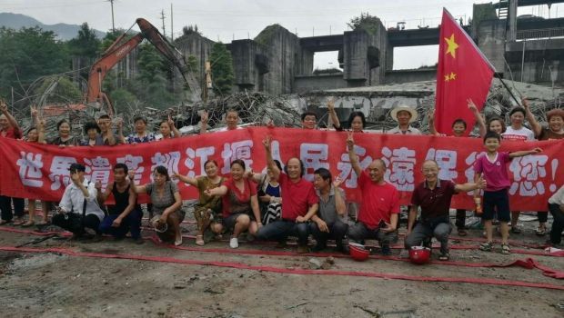 Activists celebrate the demolition of the hydropower plant. The banner reads: "We will always protect you, Dujiangyan World Heritage Site"